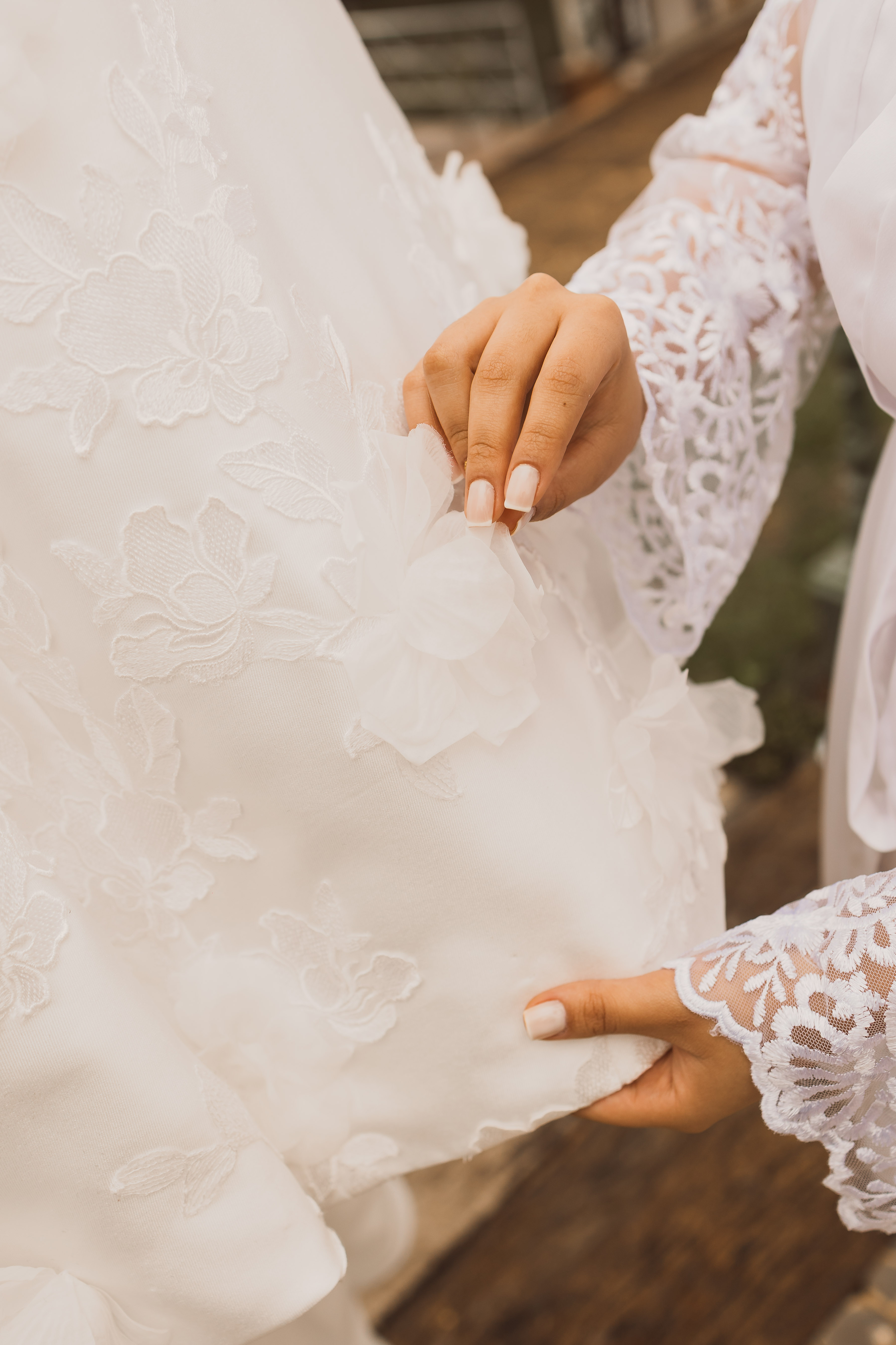 Detalhe das mãos dos noivos com alianças de ouro
